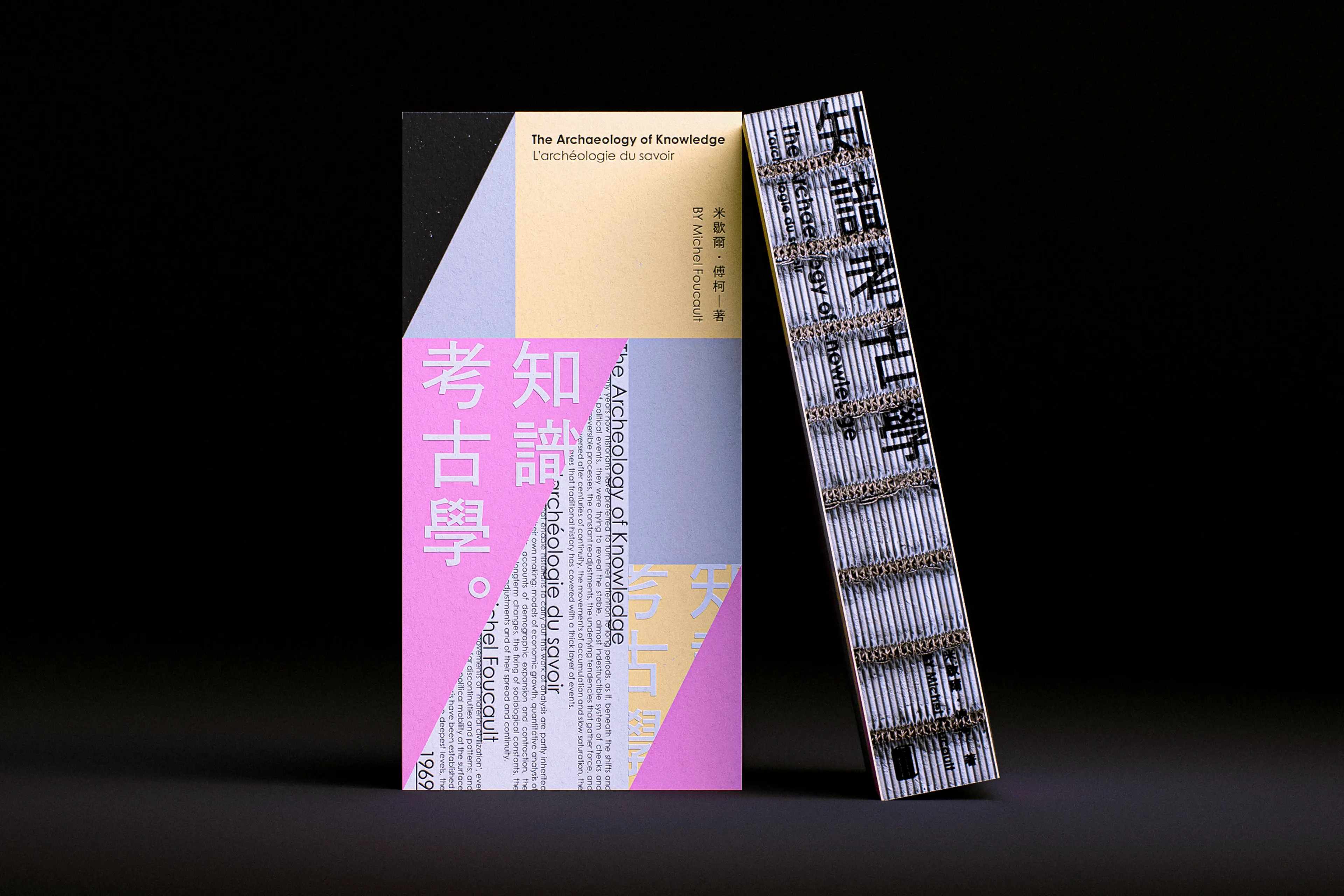 Two book cover designs for *The Archaeology of Knowledge* stand side by side against a dark background — the front cover features bold pink, pale blue, and cream geometric panels with large Chinese characters and layered bilingual typography, while the spine displays dense horizontal striped patterning with Chinese text and coil binding hardware.