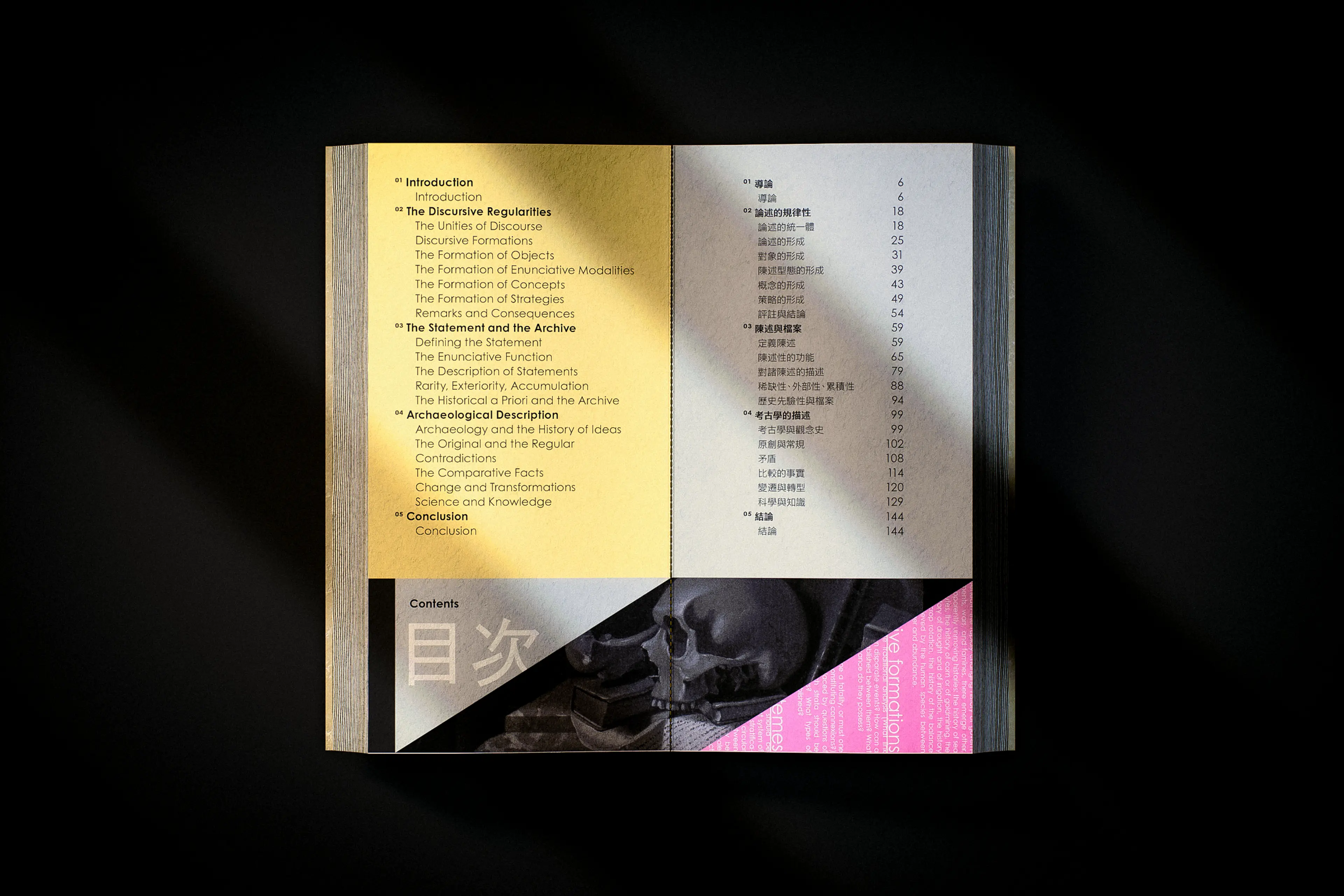 An open book spread displaying a bilingual table of contents — English on the left page over a warm yellow background, Chinese on the right — with a bold graphic inset at the bottom combining a monochrome skull image, a hot-pink diagonal block, and large Chinese characters reading "目次" (contents), set against a dark studio backdrop.